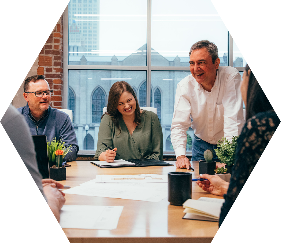 people sitting at a meeting table and smiling